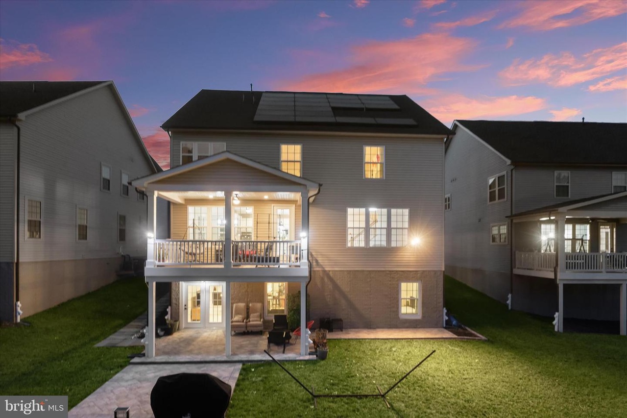 Paver patio and walkway under a covered deck at twilight behind a Maryland home